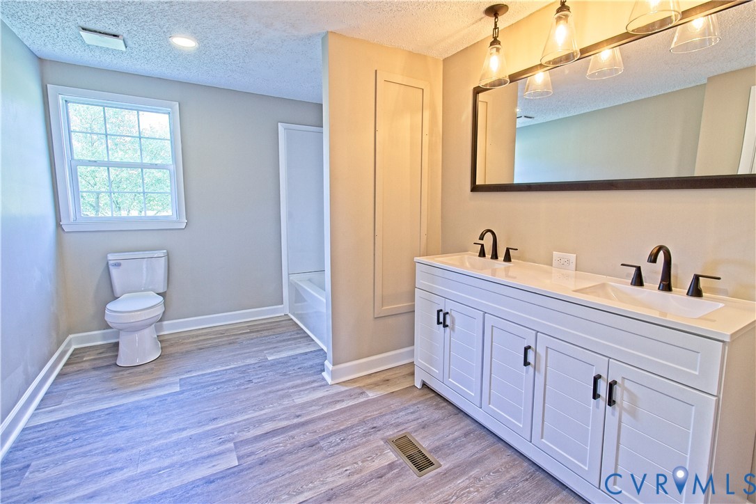 2110 Military Road Amelia Court House, VA 23002 - Photo 20 of 46 a spacious bathroom with a double vanity sink a toilet and a mirror