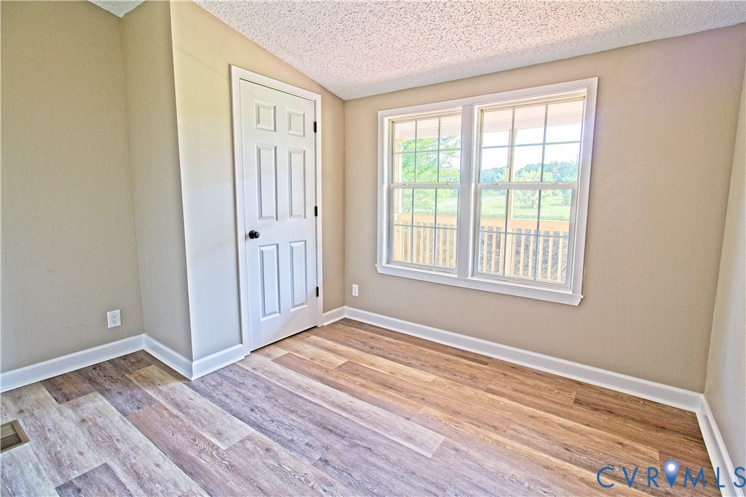 2110 Military Road Amelia Court House, VA 23002 - Photo 24 of 46 a view of an empty room with wooden floor and a window
