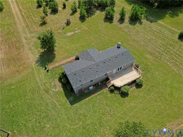 an aerial view of a house with a garden and lake view