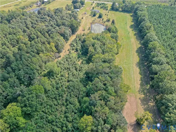 an aerial view of residential house with outdoor space and trees all around