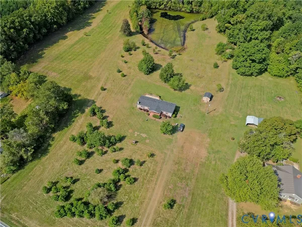 an aerial view of residential house with space and trees all around