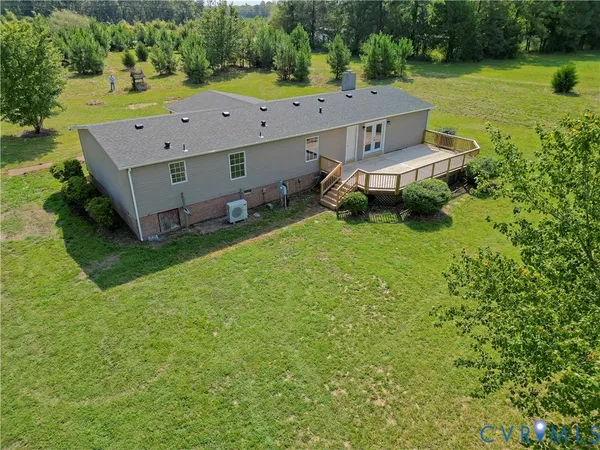an aerial view of a house with garden space and a patio