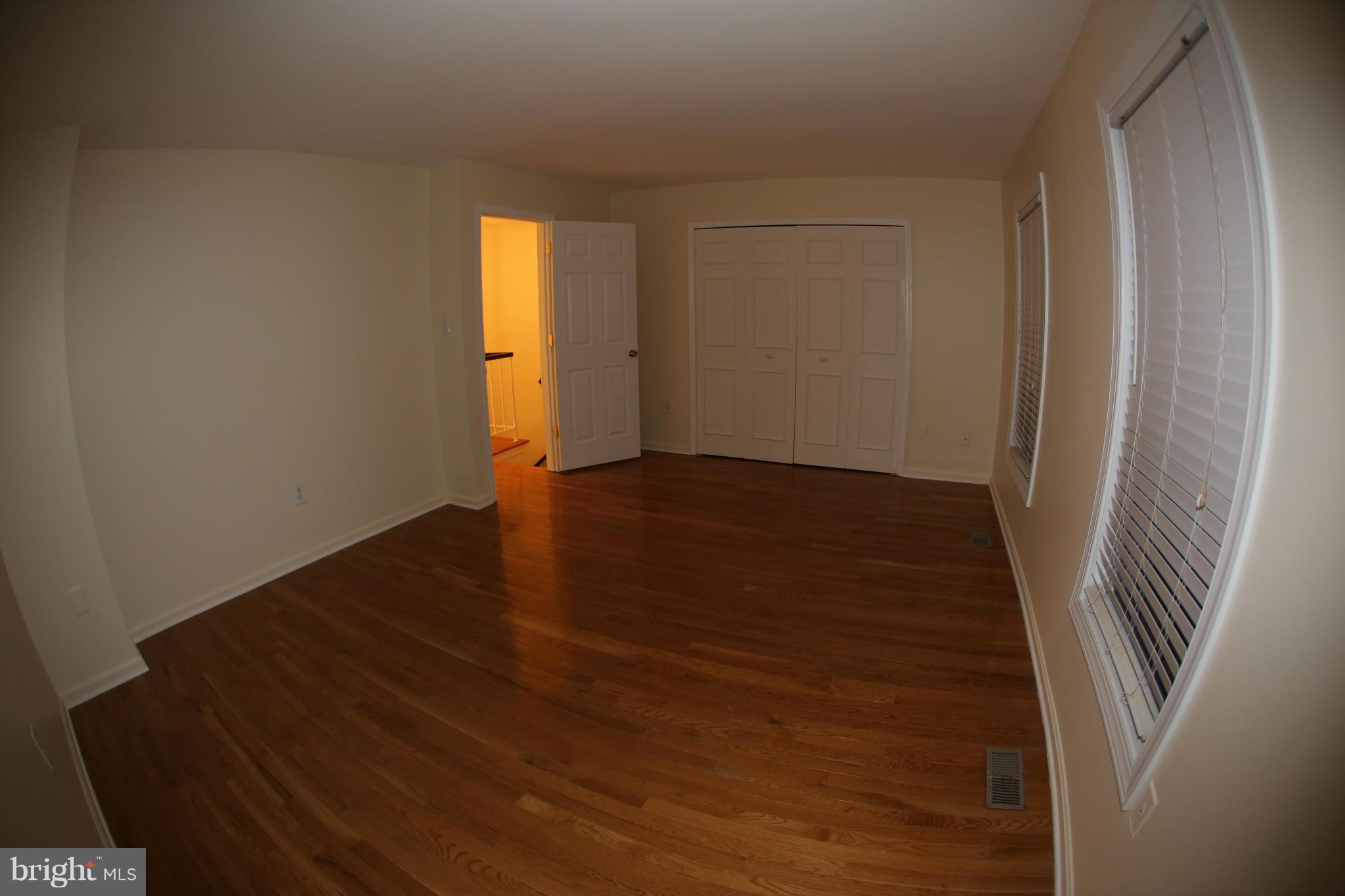8046 Felecity Court Springfield, VA 22153 - Photo 12 of 26 an empty room with wooden floor and windows