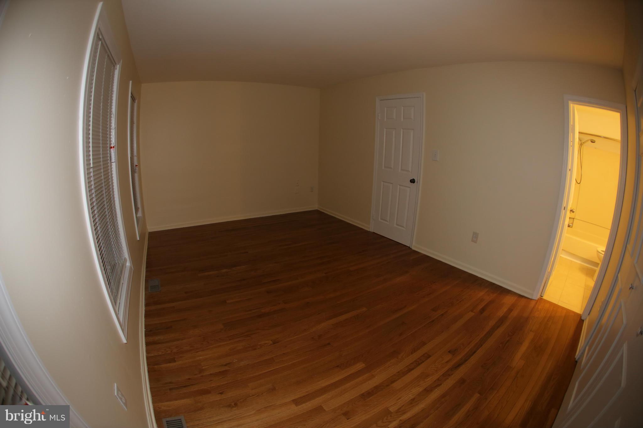 8046 Felecity Court Springfield, VA 22153 - Photo 13 of 26 a view of an empty room with wooden floor and a window
