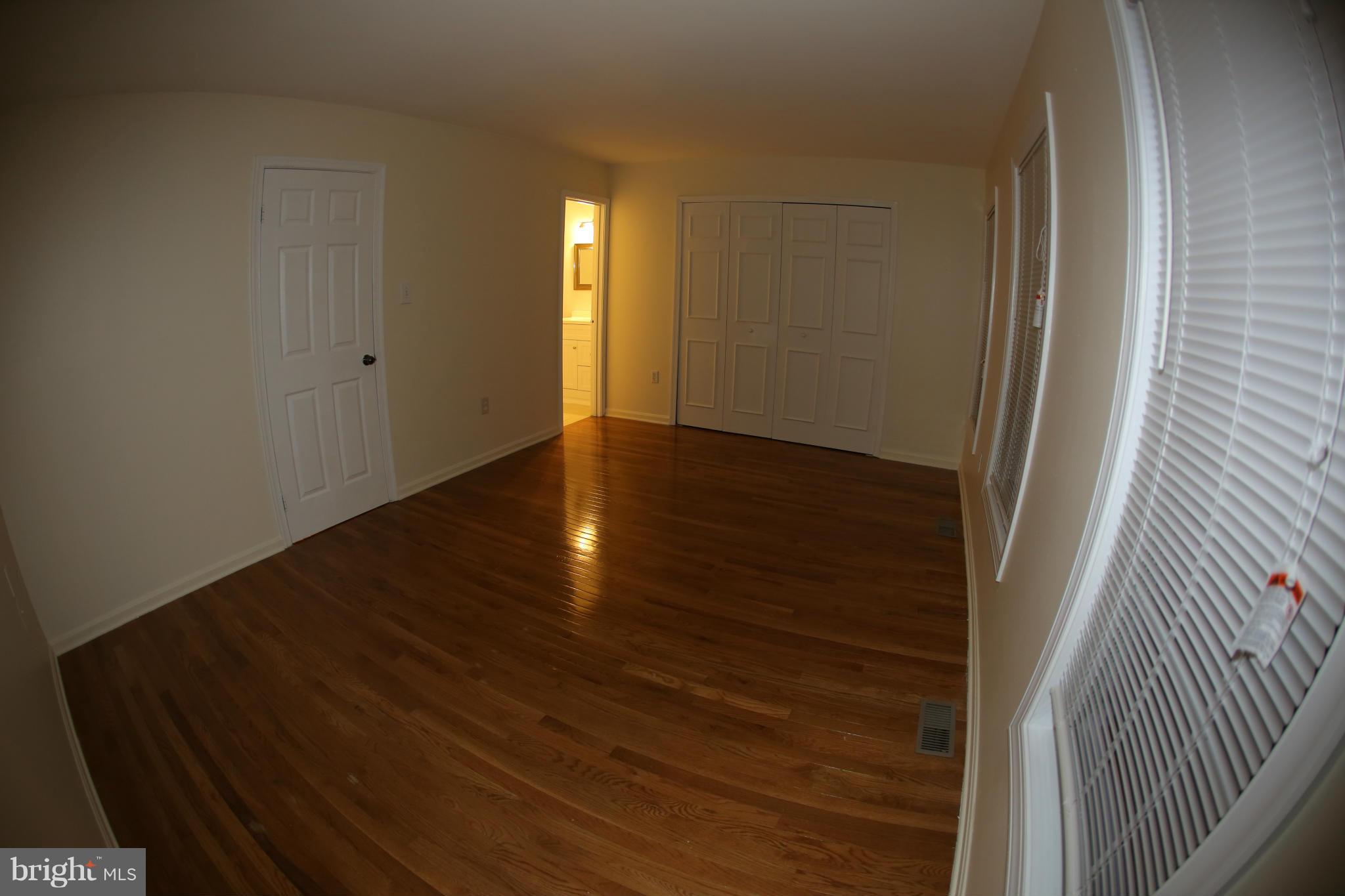 8046 Felecity Court Springfield, VA 22153 - Photo 14 of 26 a view of an empty room with wooden floor and a window