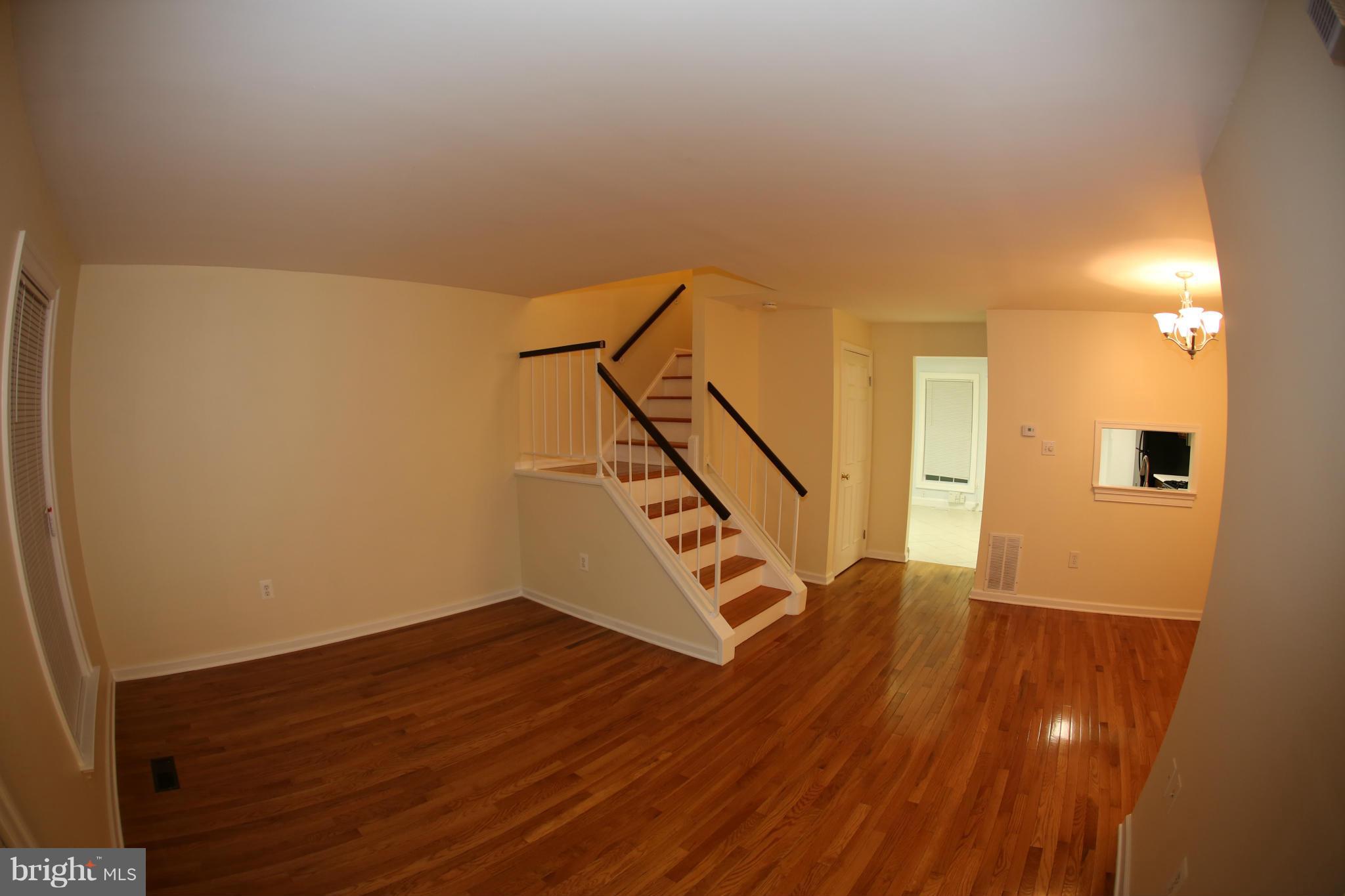 8046 Felecity Court Springfield, VA 22153 - Photo 6 of 26 a view of an empty room with wooden floor and stairs