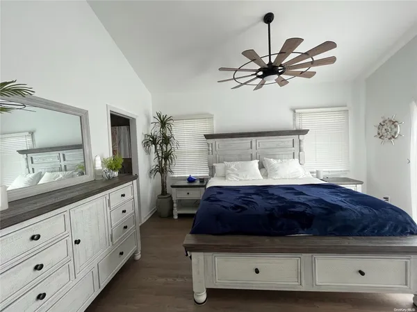 a spacious bedroom with a large bed and a chandelier