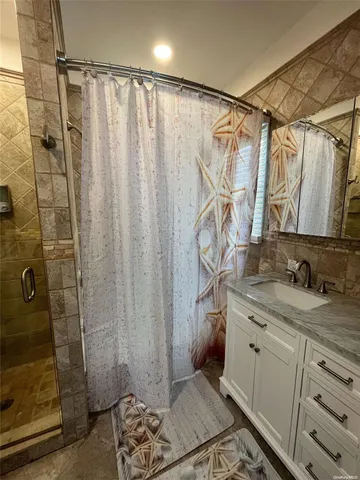 a bathroom with a granite countertop sink a shower and a mirror