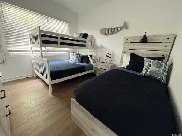 a bedroom with bed and wooden floor