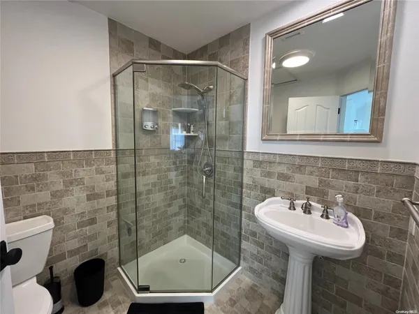 a bathroom with a sink a toilet and shower