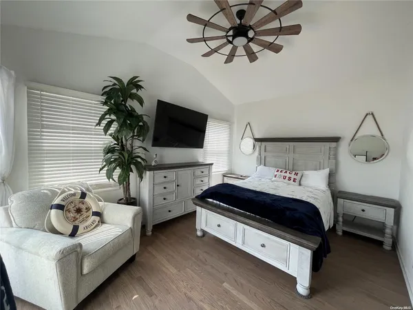 a spacious bedroom with a bed and a flat screen tv