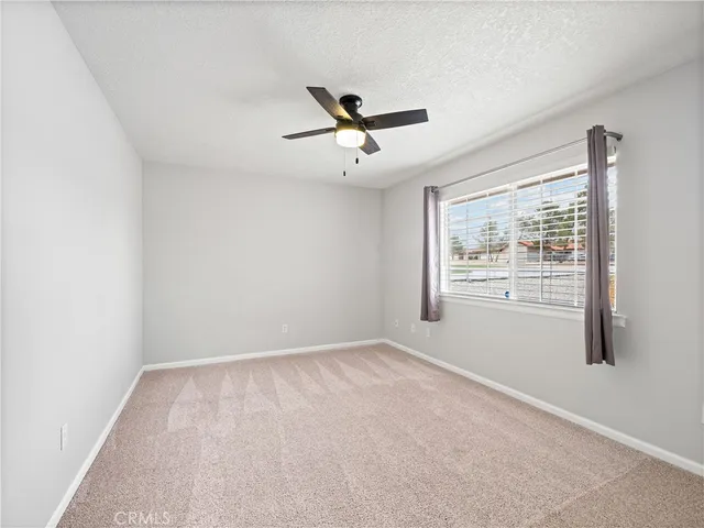 a view of a room with a ceiling fan and a window