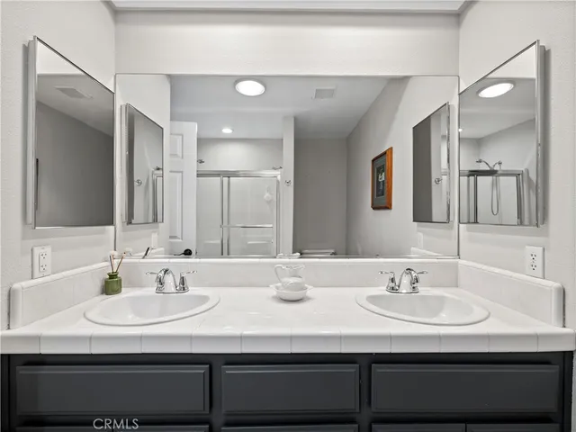 a bathroom with double vanity sinks and a mirror