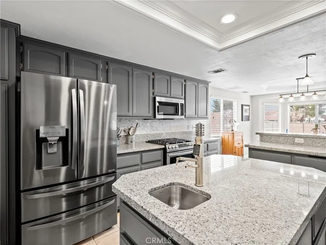 a kitchen with stainless steel appliances granite countertop a refrigerator stove and sink