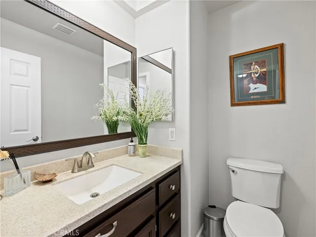 a bathroom with a granite countertop sink and a toilet
