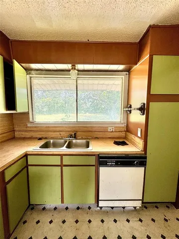 a utility room with a sink window and cabinets