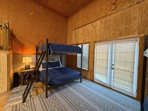 a bedroom with a bed and wooden floor