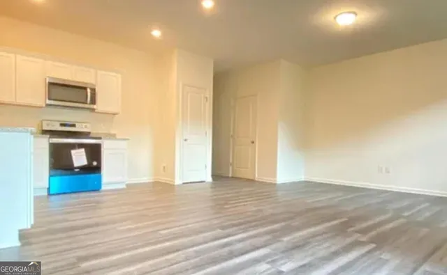 a view of a kitchen with wooden floor and a sink