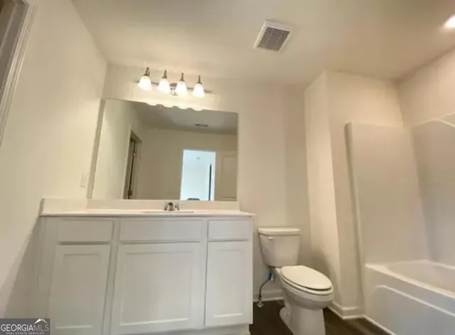 a bathroom with a sink vanity mirror and toilet