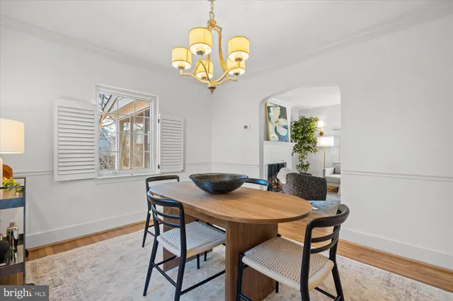 a view of a dining room with furniture a chandelier and wooden floor