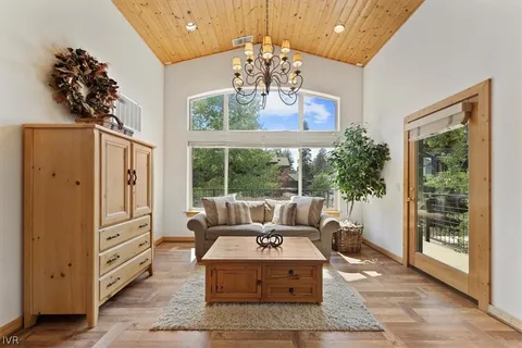 a living room with furniture large window and wooden floor