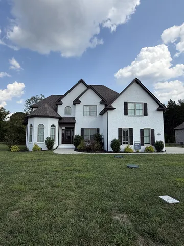 a front view of a house with a garden