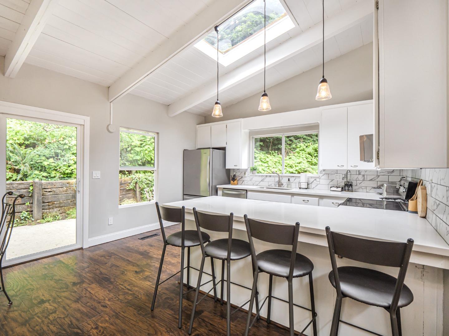 757 Cathedral Drive Aptos, CA 95003 - Photo 15 of 32 a kitchen with a dining table chairs and large window