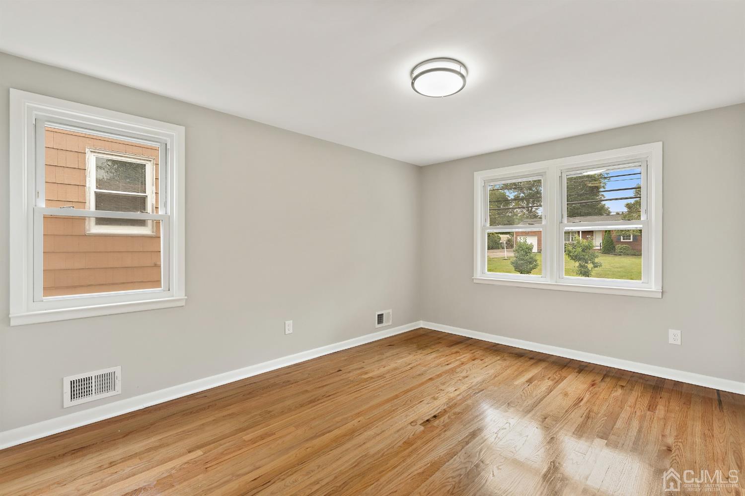 556 Chain O' Hills Road Colonia, NJ 07067 - Photo 9 of 24 a view of an empty room with wooden floor and a window