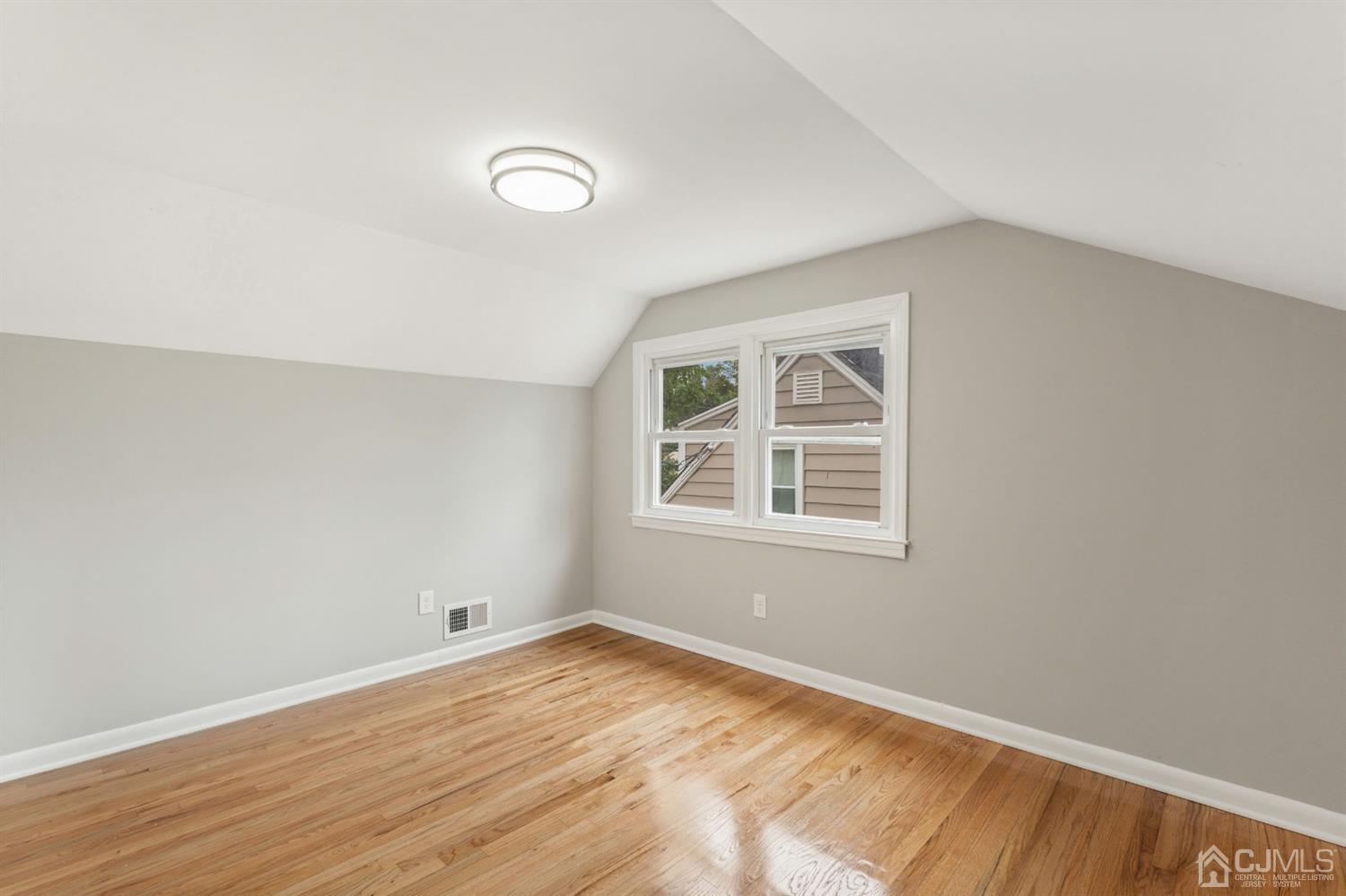 556 Chain O' Hills Road Colonia, NJ 07067 - Photo 10 of 24 an empty room with wooden floor and windows