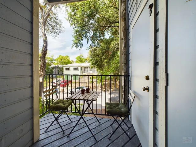 a view of a balcony with wooden floor and fence