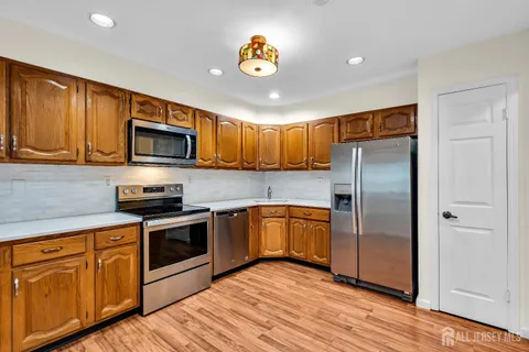 a kitchen with granite countertop a refrigerator stove top oven and sink