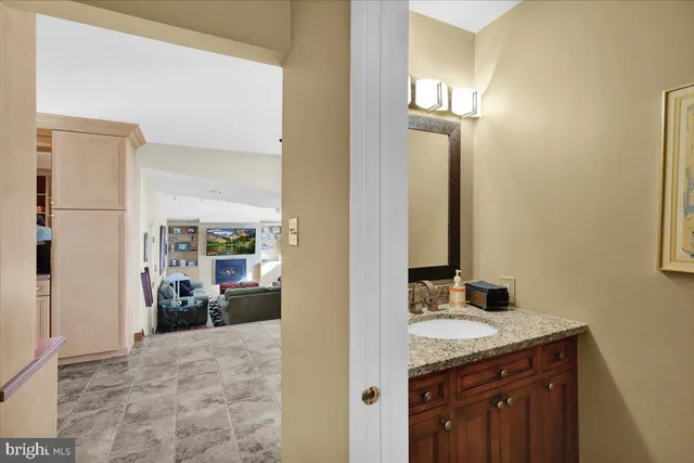 a en suite bathroom with a granite countertop sink a mirror and shower