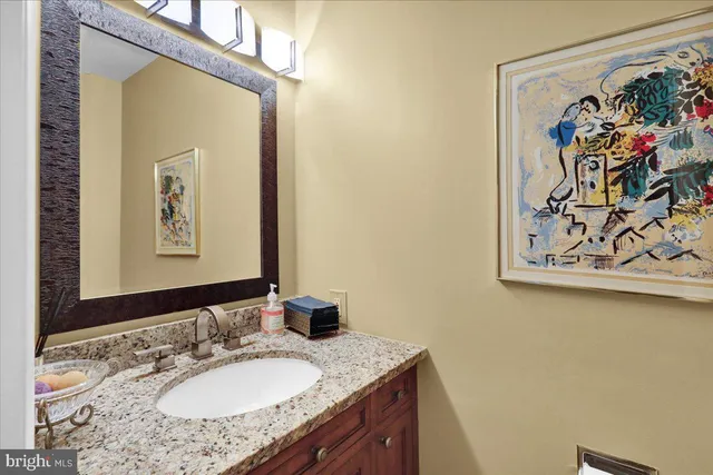 a bathroom with a granite countertop sink mirror and vanity