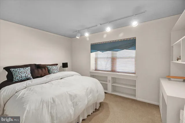 a room with lots of white furniture and stairs