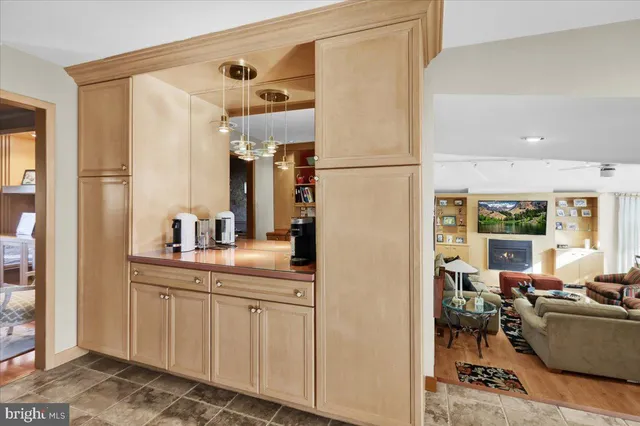 a living room with furniture a lamp and a kitchen view
