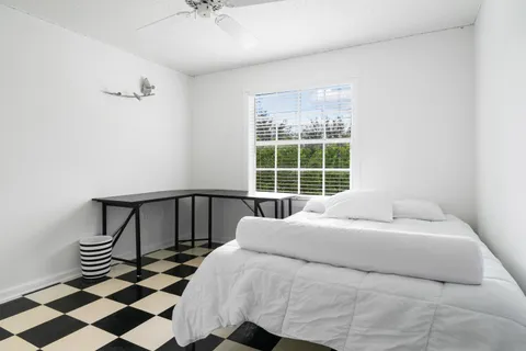 a bedroom with a bed and wooden floor