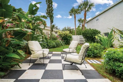 a view of a chairs and table in patio with potted plants