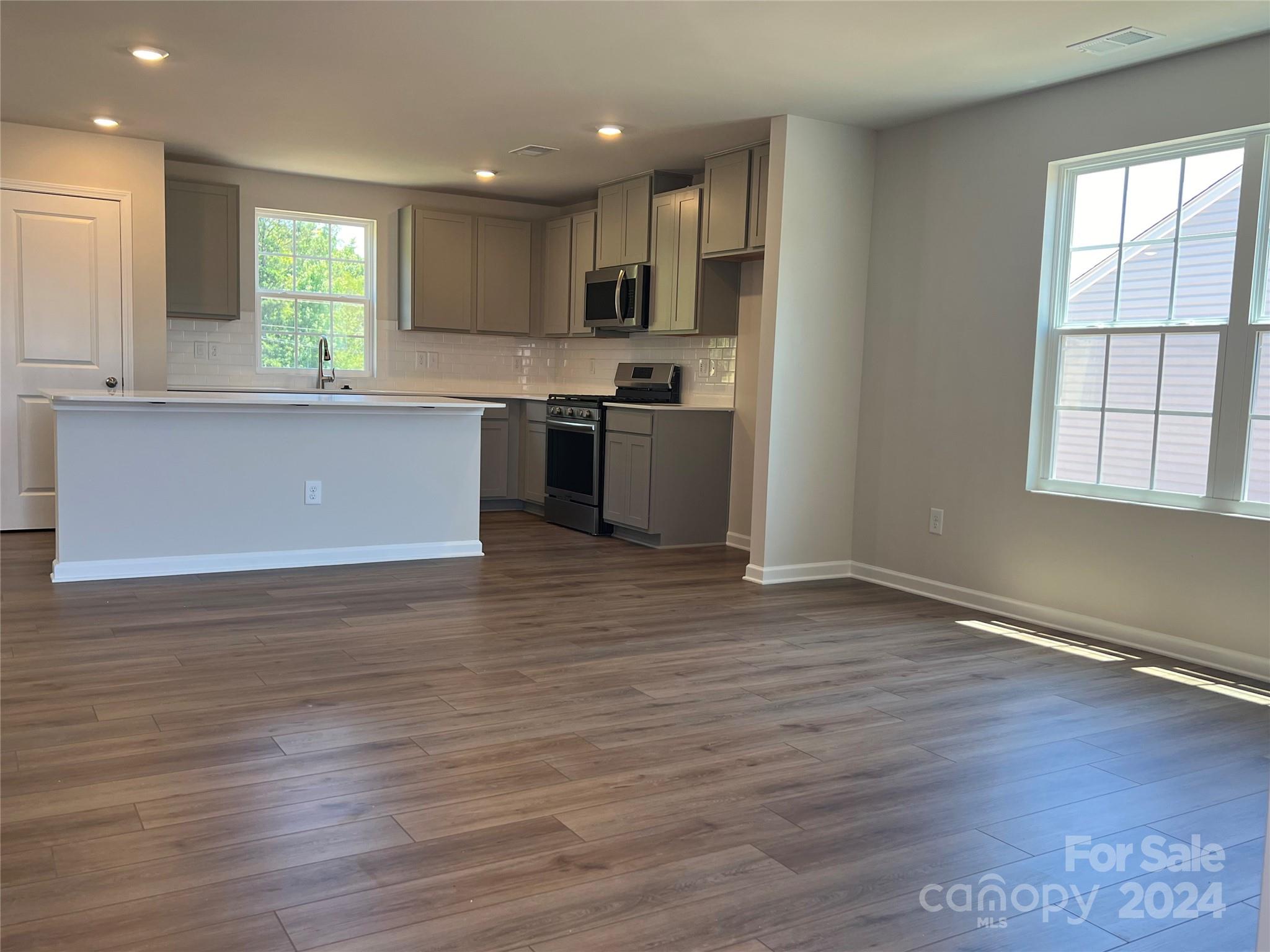 614 Mile Crk Road, Unit 30 Edgemoor, SC 29712 - Photo 6 of 31 a kitchen with granite countertop wooden floors stainless steel appliances a sink and a window