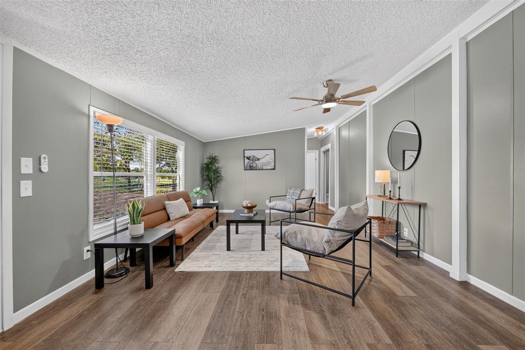 449 Big Salty Lane Springtown, TX 76082 - Photo 3 of 25 Spacious interior featuring wood-finish flooring, ample natural light from multiple windows, and a ceiling fan with integrated lighting