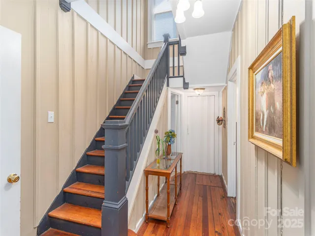 a view of staircase with wooden floor and white walls