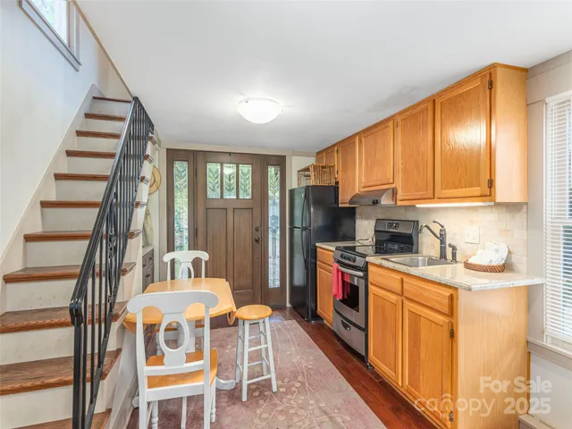 a kitchen with stainless steel appliances granite countertop a stove a sink dishwasher and a refrigerator with wooden floor