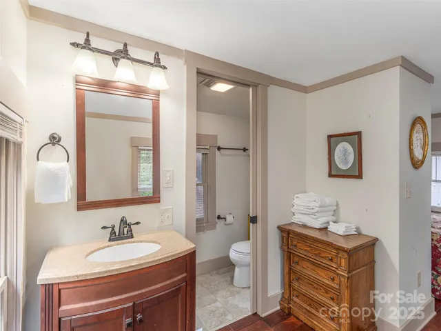 a bathroom with a toilet sink and mirror