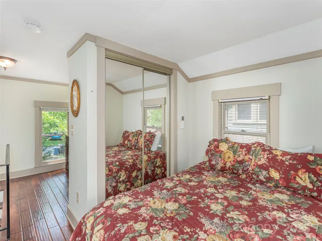 a bedroom with a bed and a dresser next to a window
