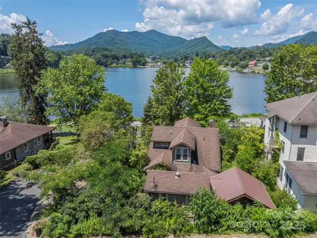an aerial view of a house with garden space and a lake view