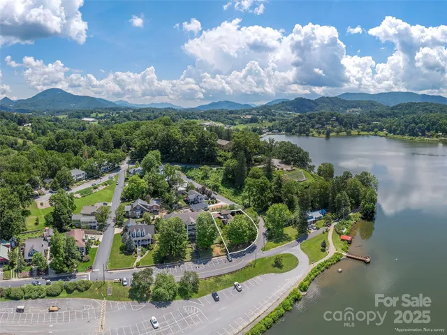 an aerial view of a city with lots of residential buildings ocean and mountain view in back
