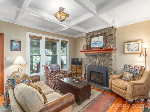 a living room with furniture fireplace and a large window