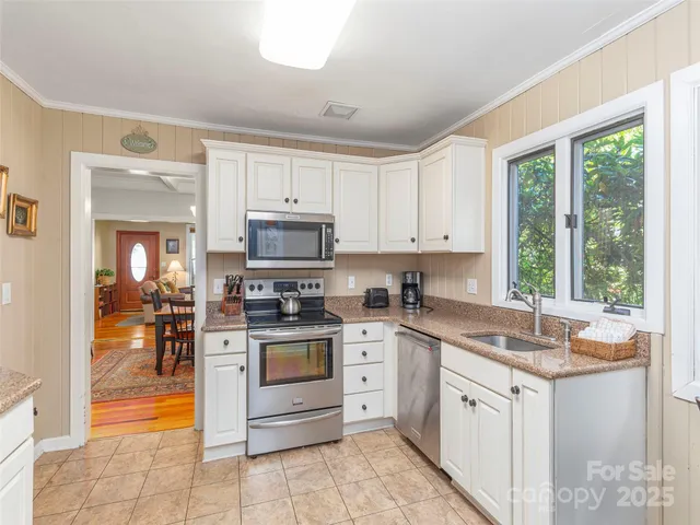 a kitchen with stainless steel appliances granite countertop a stove sink and microwave