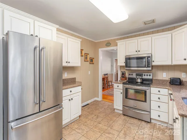 a kitchen with white cabinets and stainless steel appliances