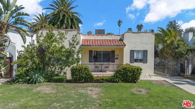 a view of a house with a yard and potted plants