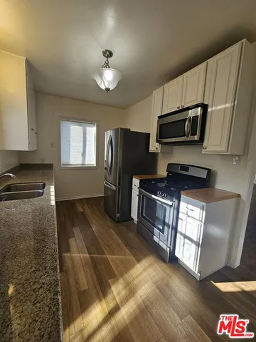 a kitchen with stainless steel appliances granite countertop a refrigerator stove and sink